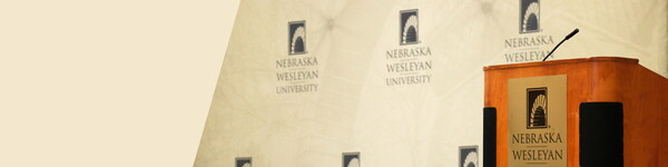 A podium and backdrop with the Nebraska Wesleyan University logo.