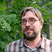 A photo of Michael Walsh standing outside in front of a tree