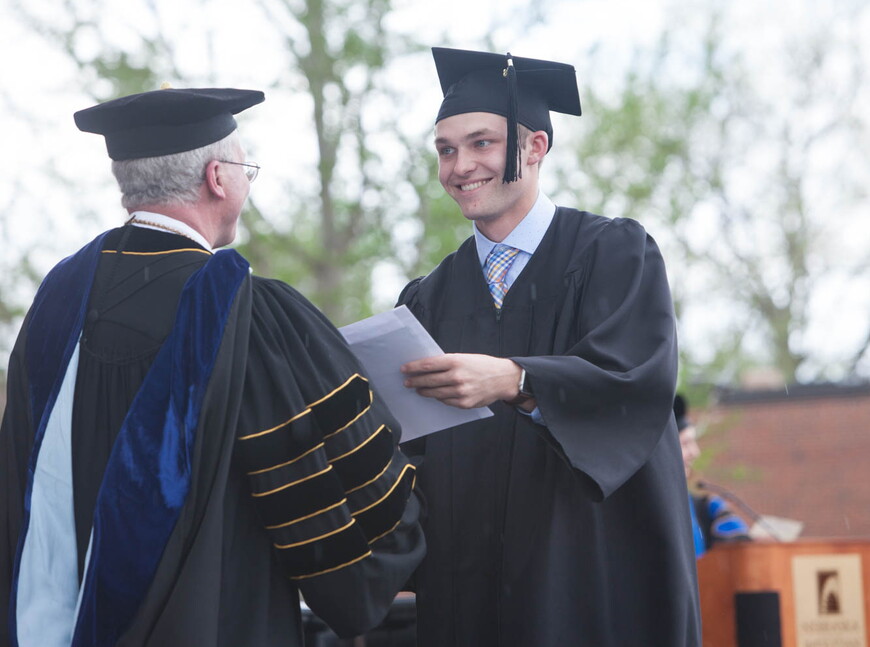 President Fred Ohles awards degrees to bachelor's degree candidates.