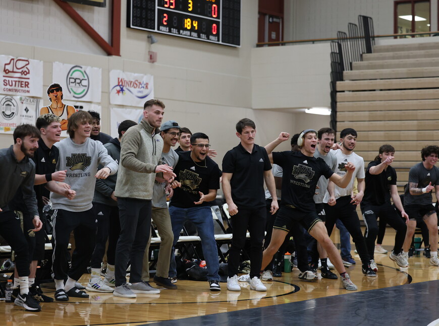 NWU wrestlers cheer on a teammate.