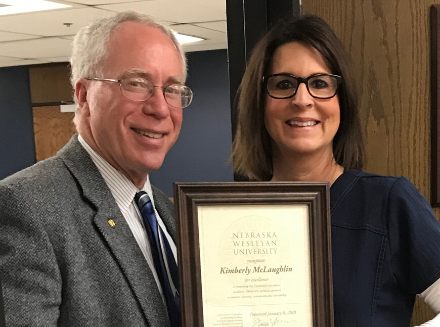 President Fred Ohles presents Kim McLaughlin, assistant director of Student Health Services, with the university's CORE Award. The award recognizes a staff member whose efforts and contributions significantly exceed expectations. 