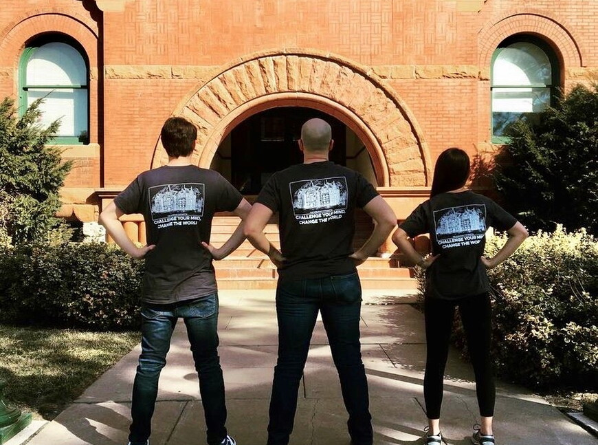 Jacob, Dr. Redding and Gayle standing with their backs to the camera. They are facing Old Main and wearing the department's tshirt.