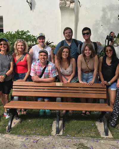 Students gather around a bench that was donated by former First Lady Michelle Obama during her visit to Cuba in 2015.
