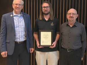 Micah Drewes holds his CORE award next to Darrin Good and Jim Ruzicka.