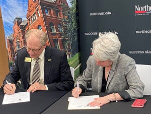 Darrin Good, president of Nebraska Wesleyan University, and Leah Barrett, president of Northeast Community College, sign an articulation agreement Thursday morning at Union 73 on the Northeast campus in Norfolk.