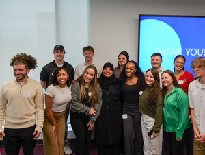 The Give to Learn Class poses for a photo with Zainab Al-Baaj of the Good Neighbor Community Center.