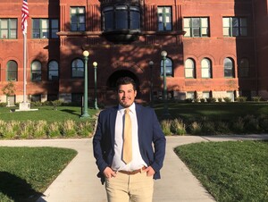 Alexis Ortega '22 in business attire in front of Old Main