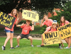 Students holding signs that say, Welcome Back.