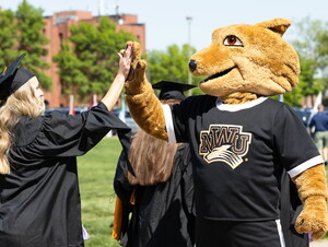 Student at commencement high five mascot