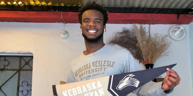 DaMicah Burtin holds a Nebraska Wesleyan University pennant.