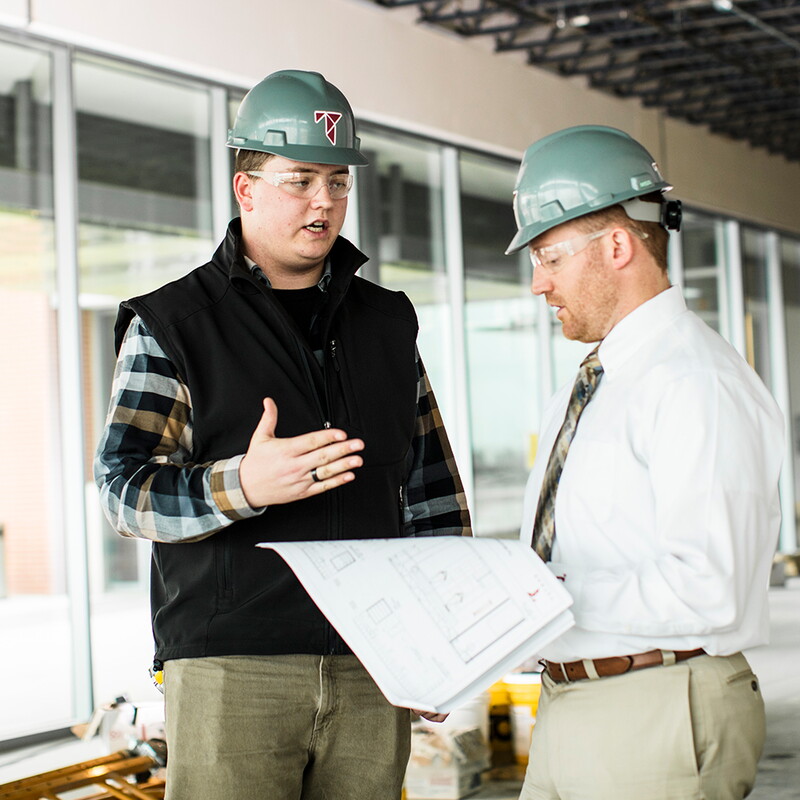 Ty Garner at a Tetrad construction site talking to the job forman.