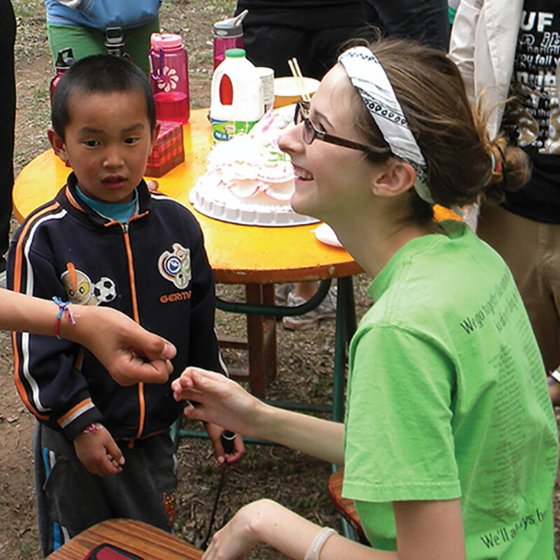 Student making bracelets for children