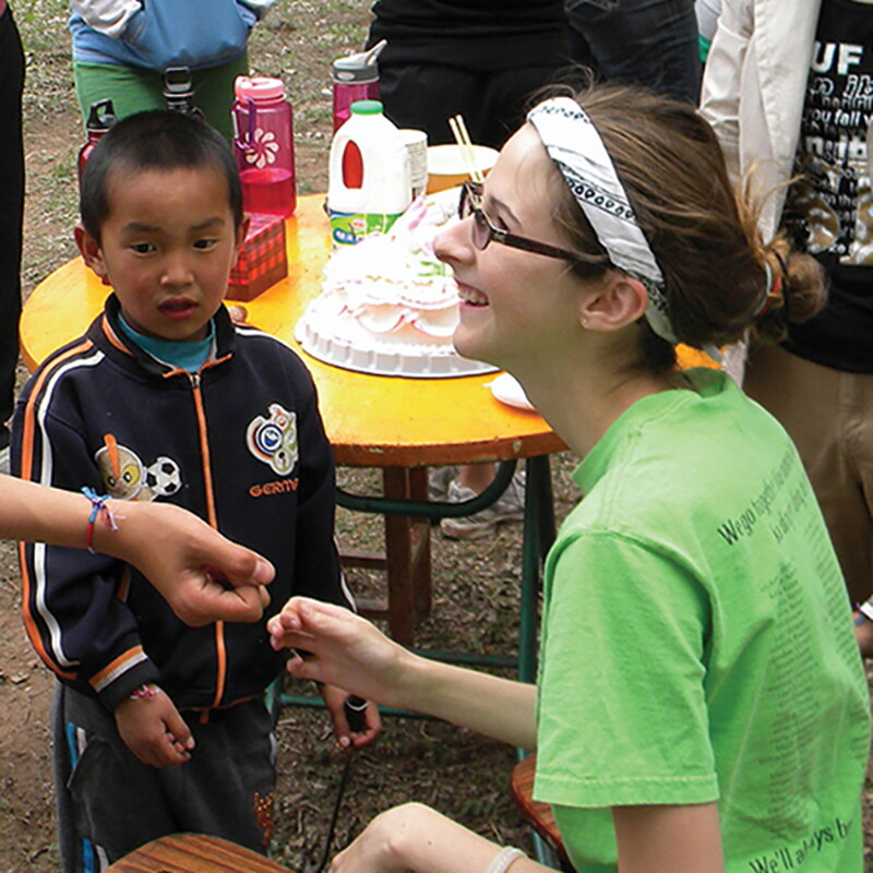 Student making bracelets for children