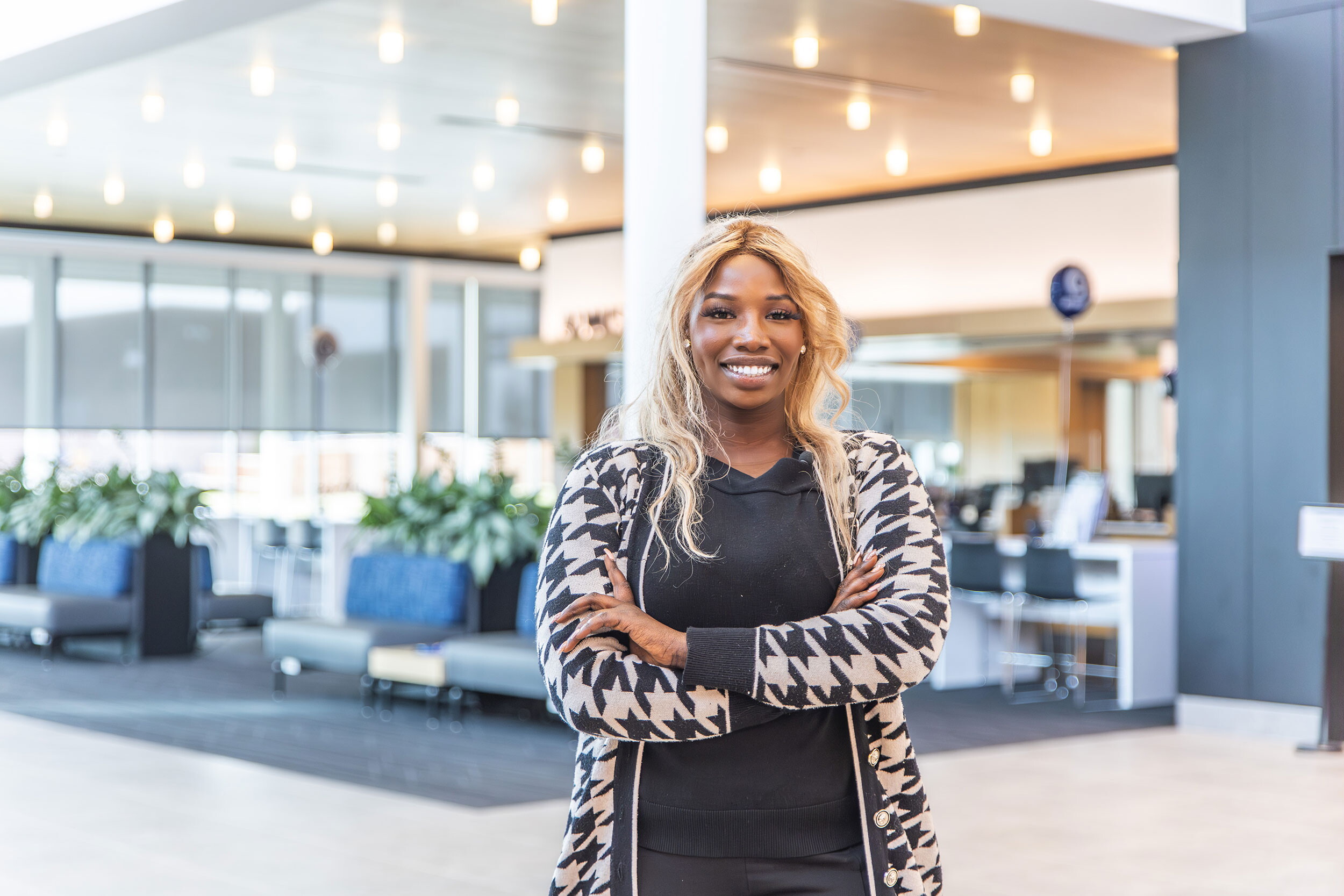 Portrait of a woman standing in a building lobby.