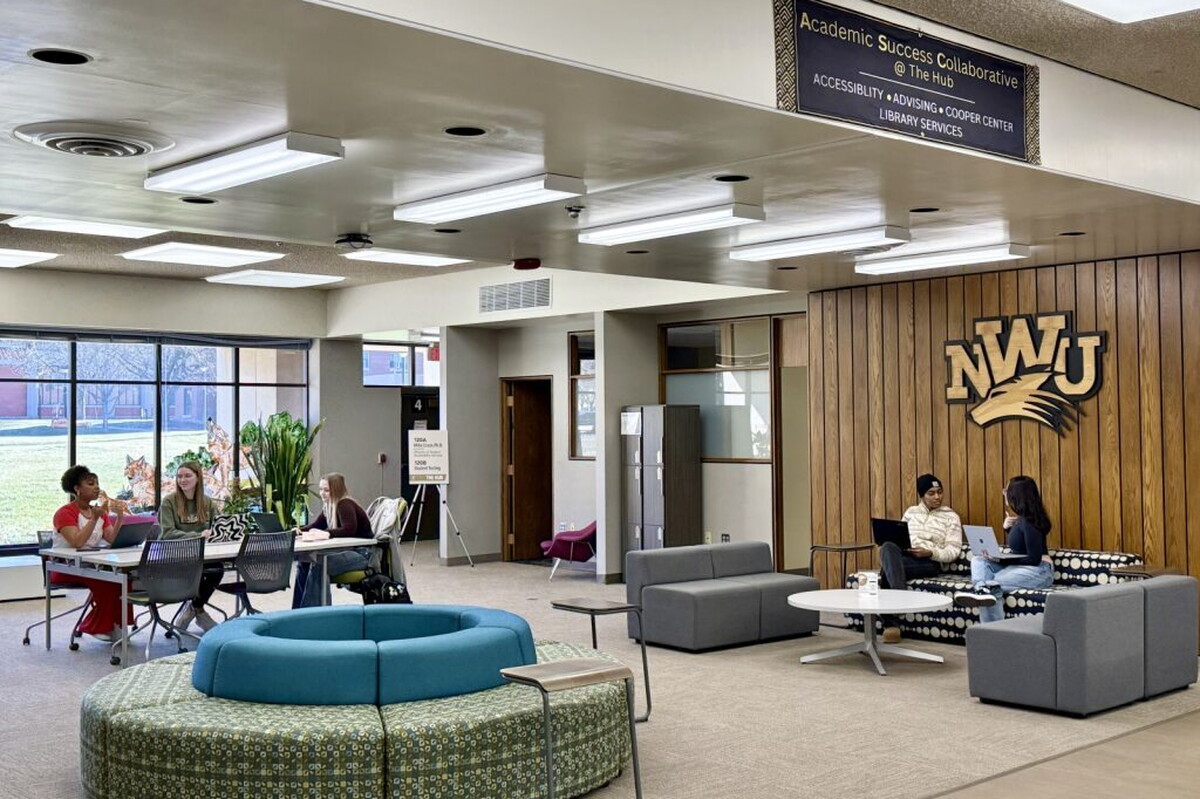The first floor of the library has students sitting in spaces studying.