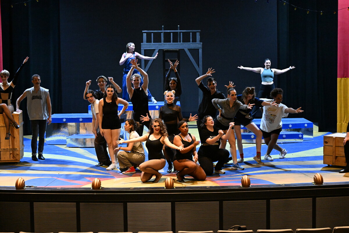 Many student actors rehearsing on a stage.