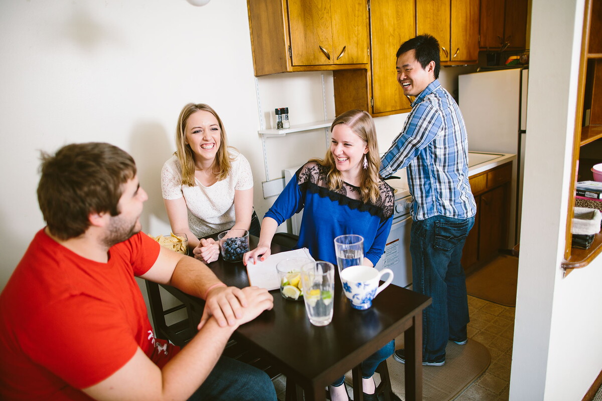 View of the apartment from the dining area looking into the kitchen with four people in the space.