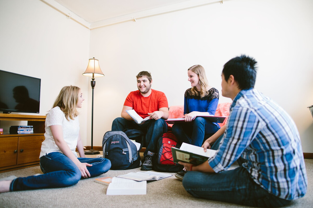 Four students studying in the living room of an apartment.