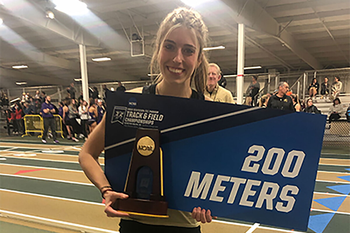 Balla Hogue holding a 200 Meters sign at a track meet