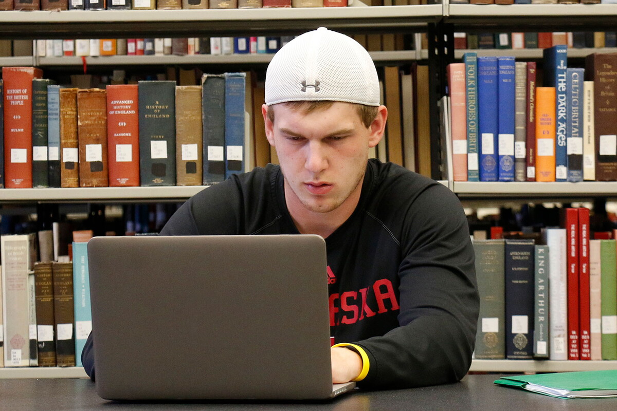 Male student in the library on a laptop