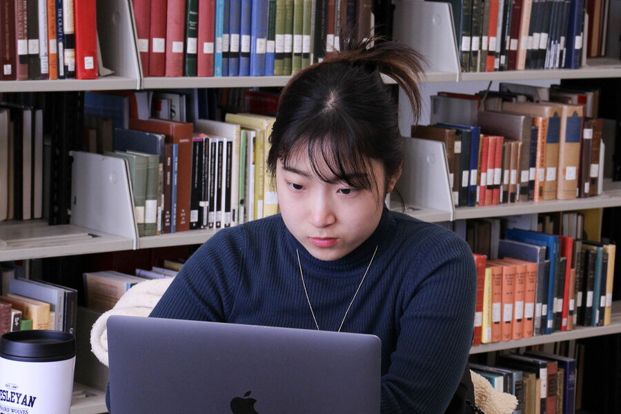 Young woman in the library on a laptop.
