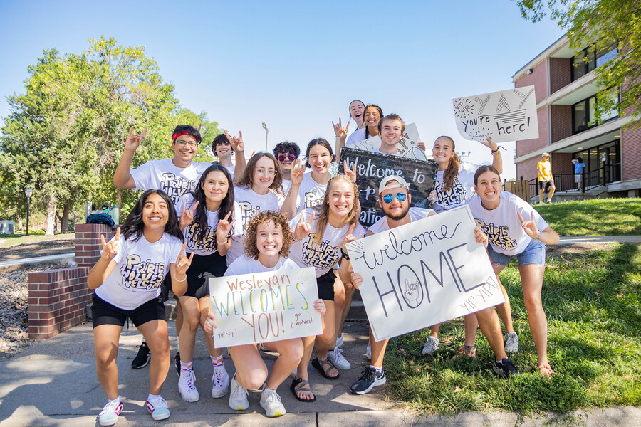 A group of NWU students holding welcome signs.