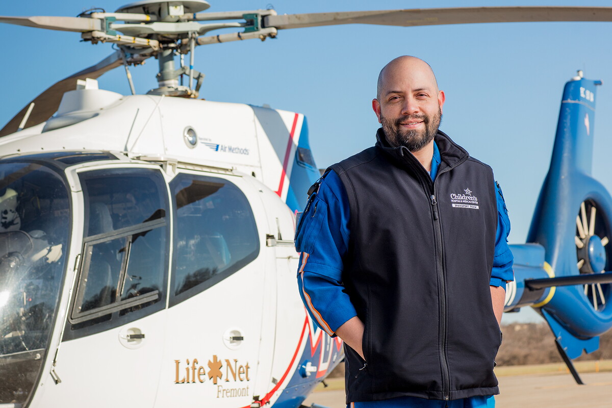 Philip Armendariz, transport nurse, in front of a rescue helicopter