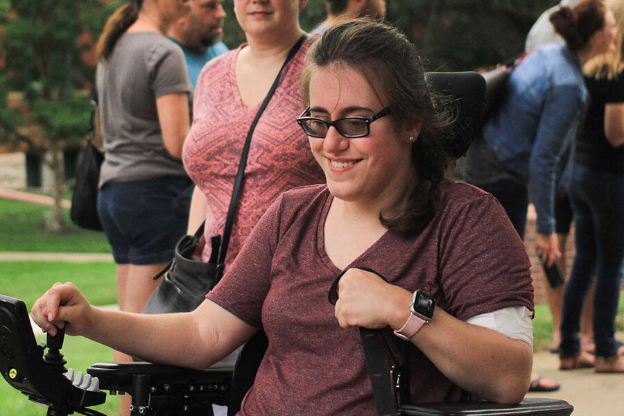 Female student navigates her wheelchair during new student welcome event.