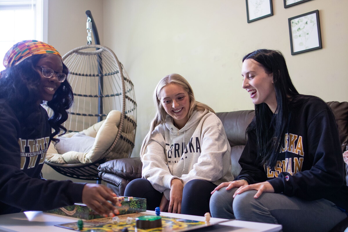 Young women playing a game in the living room of a suite.