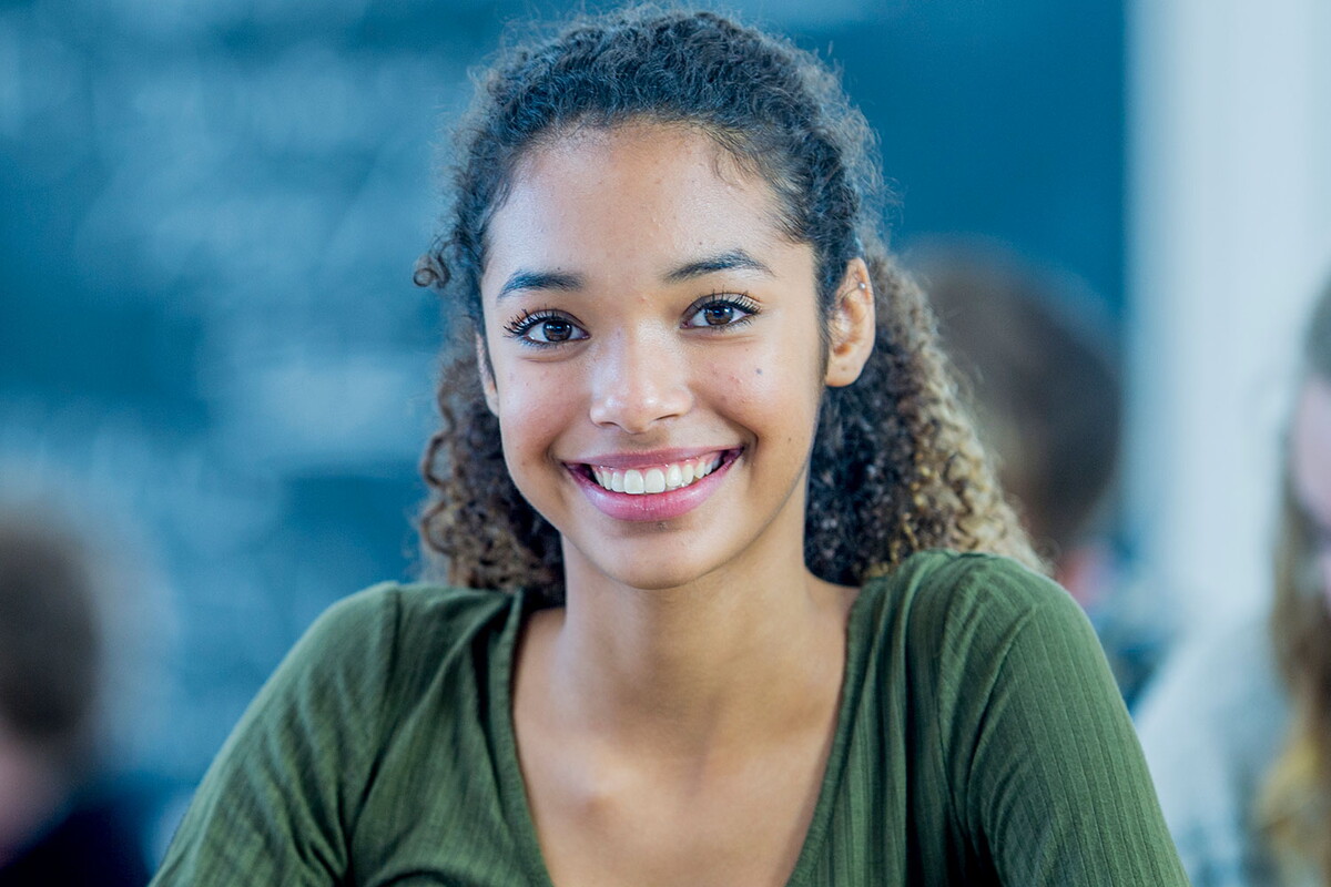 student in a classroom smiling