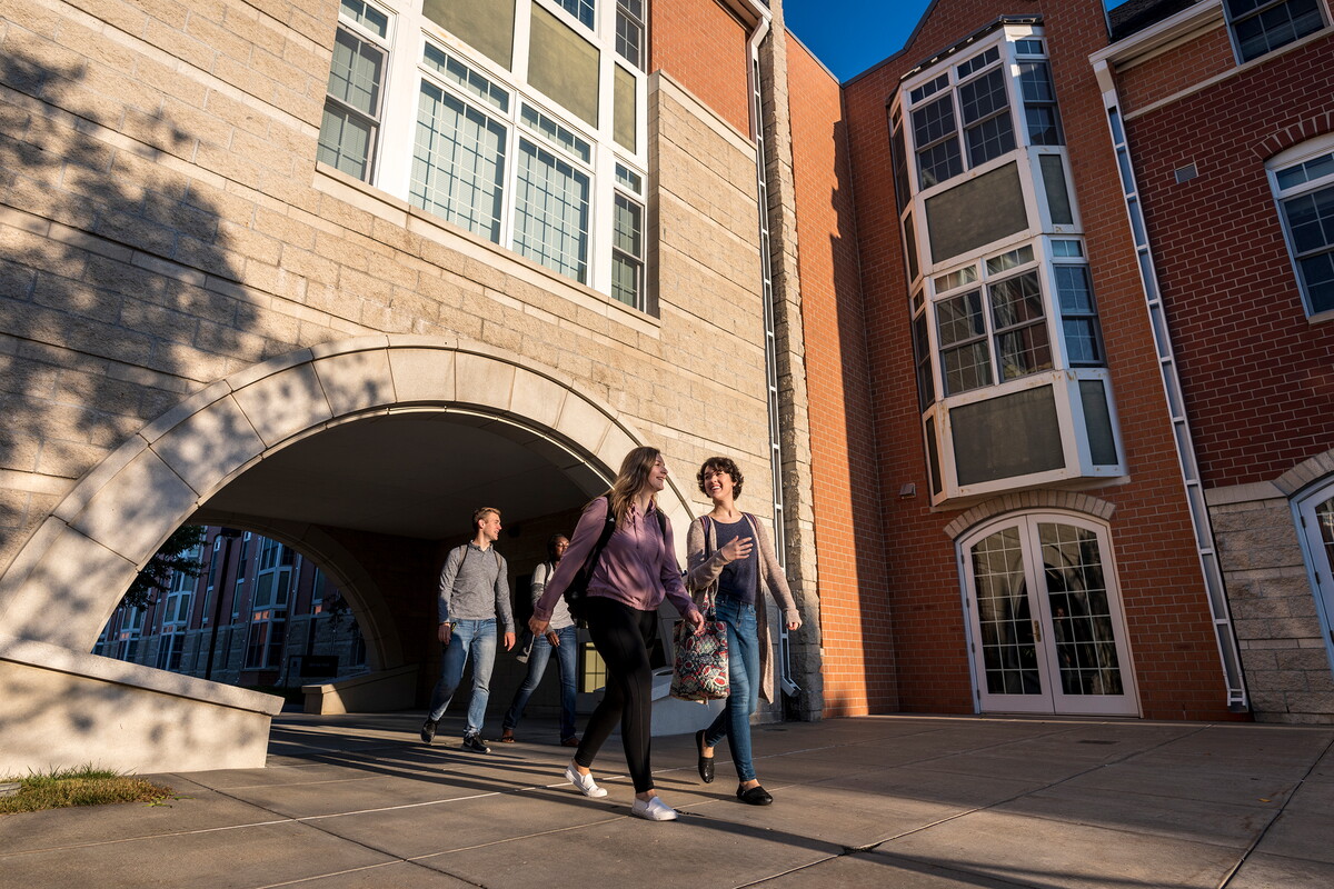 Students walk under arch in suite apartments