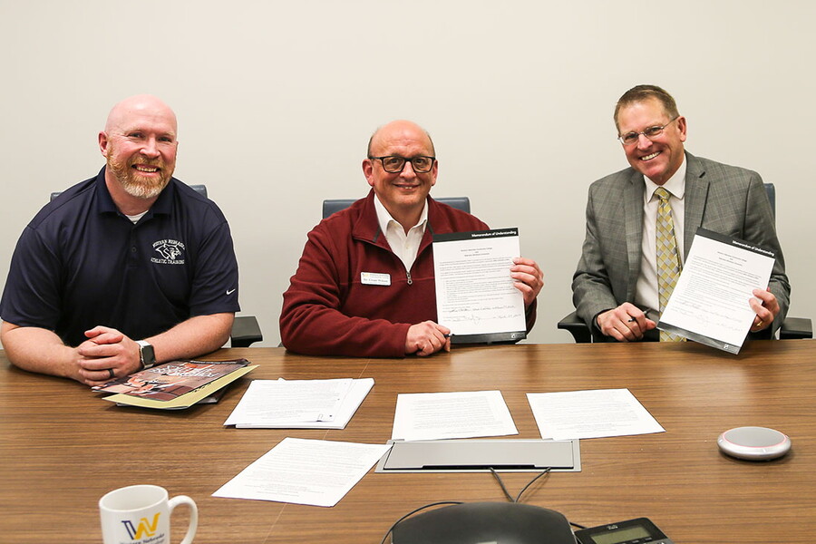 Two NWU employees and two WNCC employees signing agreement 