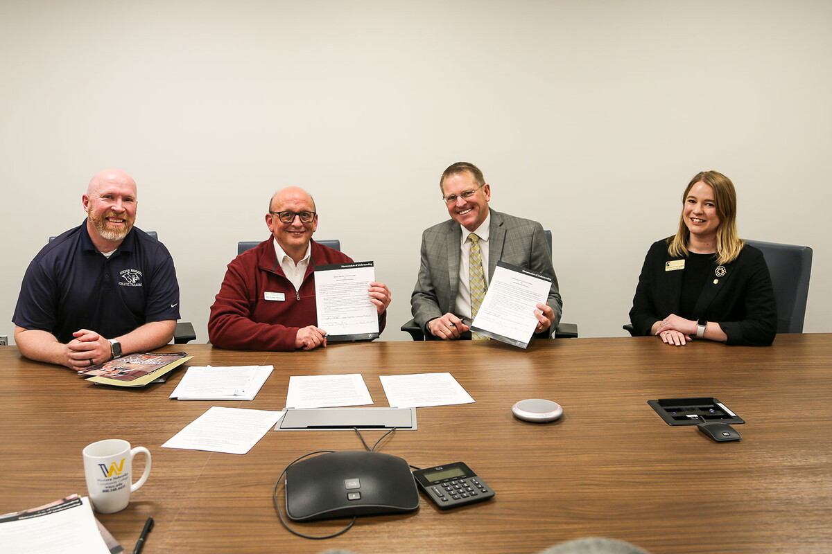 Two NWU employees and two WNCC employees signing agreement 