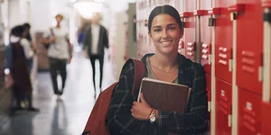 High school girl leaning against a locker