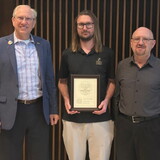 Micah Drewes holds his CORE award next to Darrin Good and Jim Ruzicka.