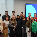 The Give to Learn Class poses for a photo with Zainab Al-Baaj of the Good Neighbor Community Center.