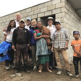 Members of GSL stand alongside the family that will live in the home. The homes are earthquake-proof and include a bedroom, bathroom and shower.