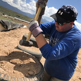 Earthships typically use over 600 recycled tires that build the main retaining wall for the home's structure. Garner pounds a tire with dirt and cardboard, which makes the tire a firm structural component and insulation tool.