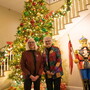 A couple of women standing in front of a Christmas tree. 